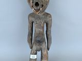 une image représentant une figurine en bois sur la poitrine de laquelle est accrochée une étiquette blanche