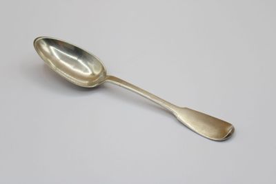 silver spoon on a white table with a white background