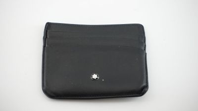 portefeuille en cuir noir sur fond blanc, orné d'une petite fleur blanche