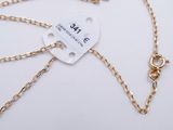 a close up of a gold chain with a tag attached to it