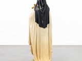 statue of a woman in a black and white robe and a black scarf