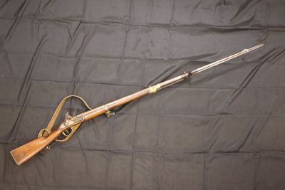 the rifle is laying on a black cloth with a wooden handle