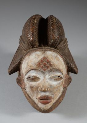 a close up of a wooden mask on a white surface
