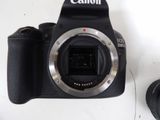 a canon camera sitting next to a canon lens on a table