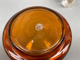 a brown glass bowl with a silver lid on a table