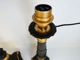 a black and gold lamp that is on a table