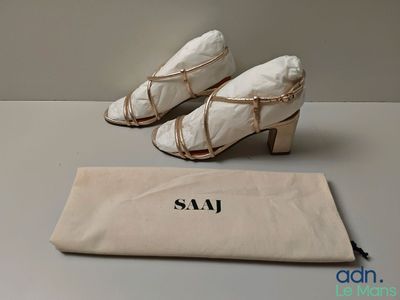 the pair of shoes are sitting next to a bag on the table