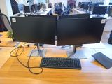 two computer monitors and a keyboard on a desk