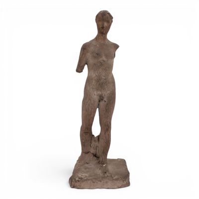 a statue of a man standing on a rock with his hands in his pockets