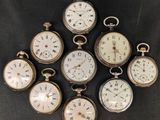 six antique pocket watches are arranged in a circle on a black surface