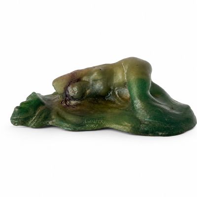 une figurine représentant une grenouille allongée par terre