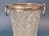 a glass vase with a metal handle on a blue background