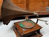un vieux gramophone posé sur une table en bois près d'un mur