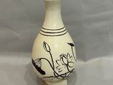 un vase blanc orné de motifs noirs sur fond blanc
