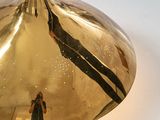 a gold colored light that is hanging from the ceiling