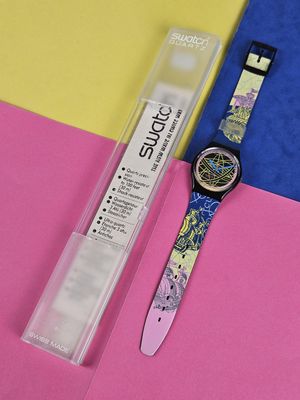 a watch that is sitting on a pink and yellow surface