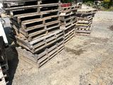 a man standing in front of a pile of pallets