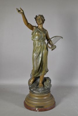 statue en bronze représentant une femme tenant une raquette de tennis et une balle de tennis