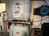 une photo d'un réservoir muni d'un tuyau, dans un garage