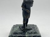 an image of a statue of a man standing on a marble base