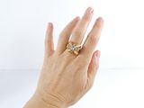 a woman ' s hand with a gold ring on it