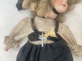 a doll that is laying down on a white surface
