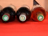 several bottles of wine are lined up on a red table