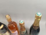 several bottles of wine are lined up on a white surface