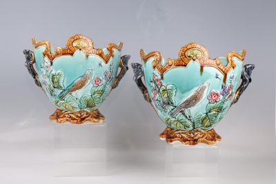 pair of vases with birds and flowers painted on them sitting on a table