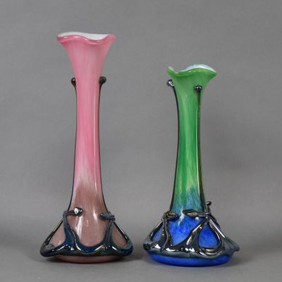 three different colored glass vases sitting next to each other on a gray surface