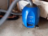 un aspirateur bleu posé par terre