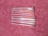 six silverware spoons on a pink cloth with a red background