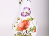 un vase blanc sur lequel sont peintes des fleurs colorées