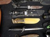 many different types of knives on a black surface