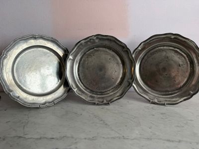 trois assiettes en argent posées les unes à côté des autres sur une table