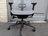 an office chair with a seat that has a black base and a white mesh back