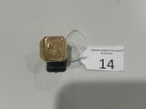 une bague en or posée sur une table blanche, avec une étiquette de prix