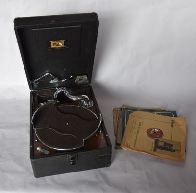 an old record player sitting in a suitcase next to a stack of books