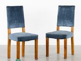 pair of blue velvet dining chairs with wooden legs and backrests