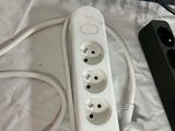 a cord connected to a power strip and a surger on a bed