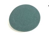a green disc on a white surface next to a black object