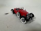a red model of a car on a white surface