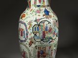 a vase with a painting on it sitting on a table
