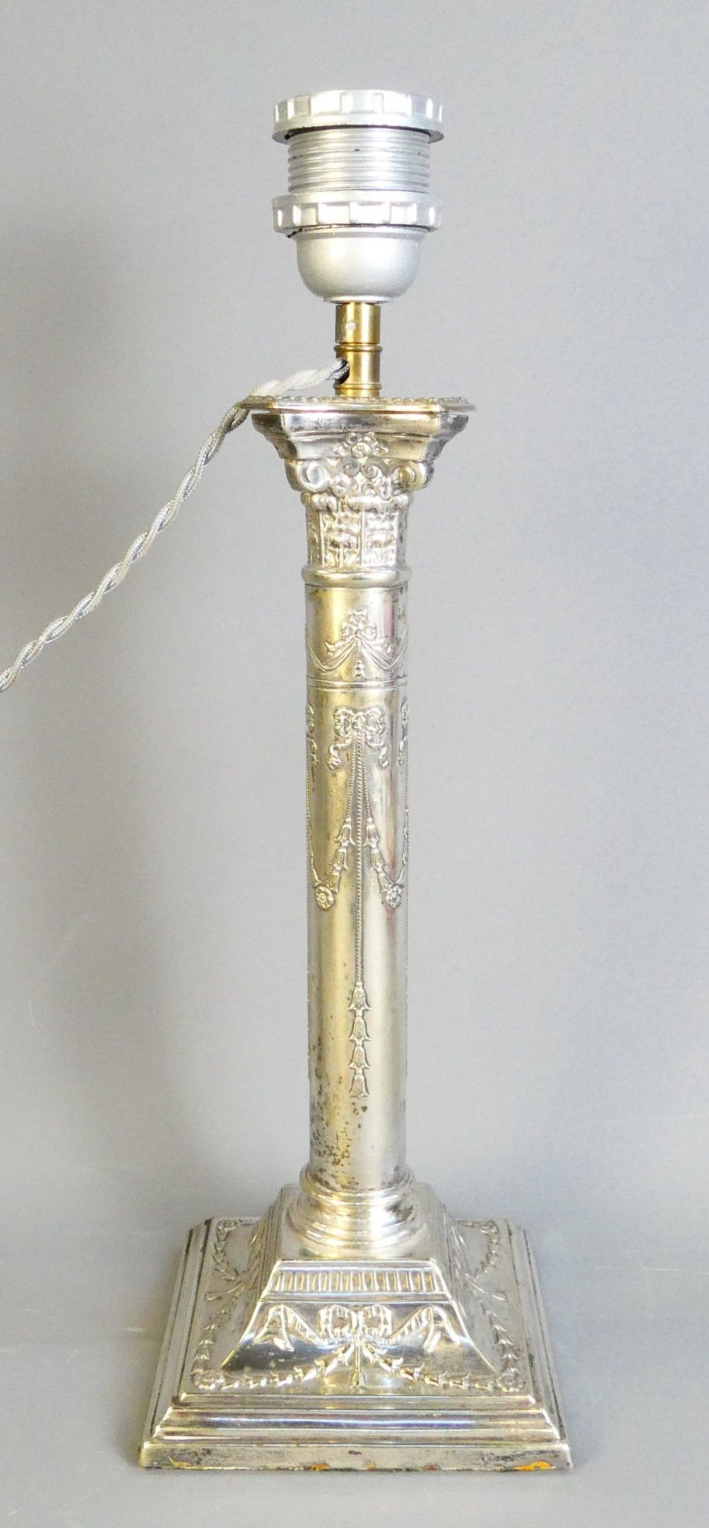 Pied de lampe en métal argenté, figurant une colonne à décor…