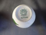 a close up of a white vase with a green design on it