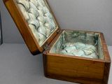 une petite boîte en bois contenant des poissons, posée sur une table