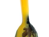 a yellow vase that has a picture of a forest on it