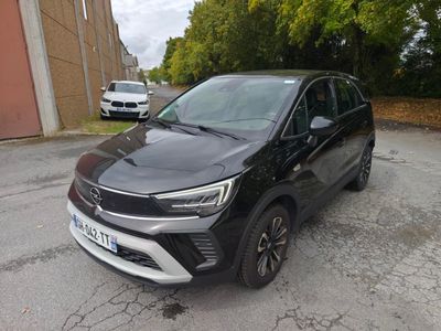 une voiture noire garée dans un parking à côté d'un bâtiment