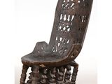 an old wooden chair with carvings on the back