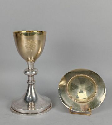 une coupe et une assiette en argent posées l'une à côté de l'autre sur une table